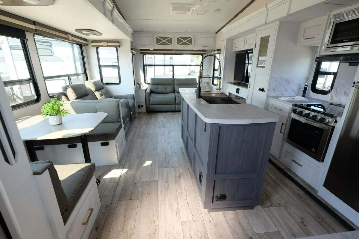 Interior view of the RV with a dinette, living space and a kitchen.