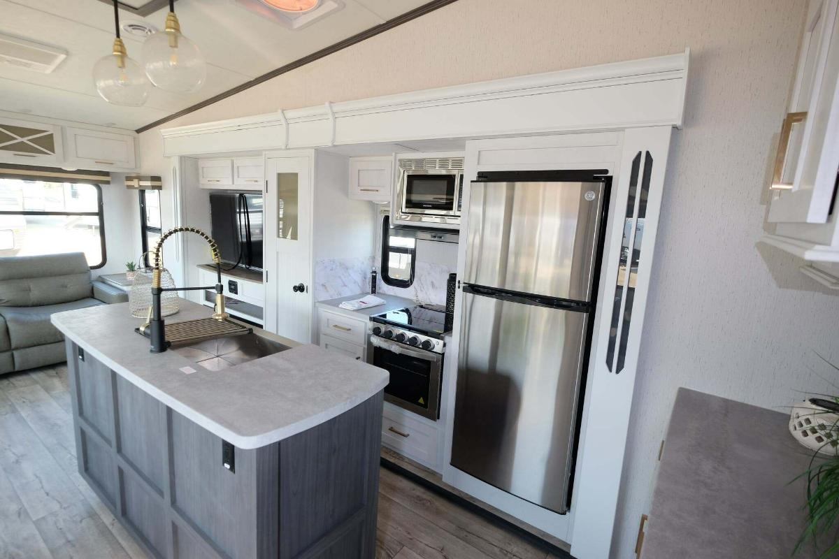 Kitchen with a gas range, fridge, oven, sink and cabinets.