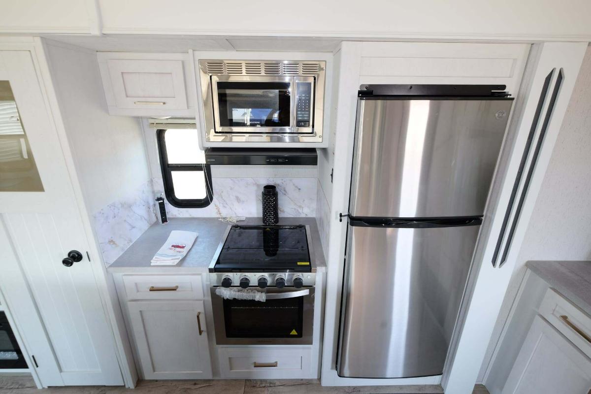 Kitchen with a gas range, fridge, oven, and cabinets.