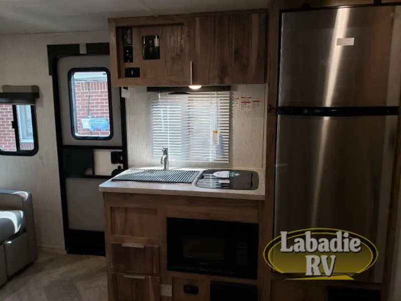 Kitchen with a gas range, fridge, sink and cabinets.