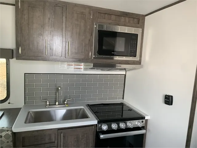 Kitchen with a gas range, oven, sink and cabinets.