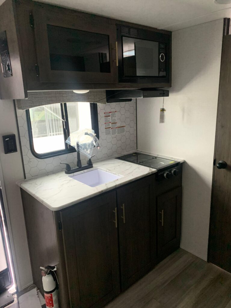 Kitchen with a gas burner, oven, sink and cabinets.