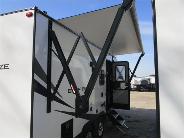 Side view of the RV with an awning.