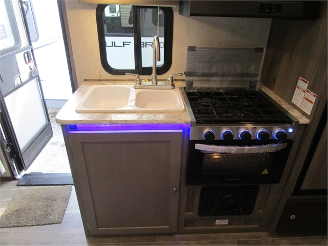 Kitchen with a gas burner, sink and cabinets.