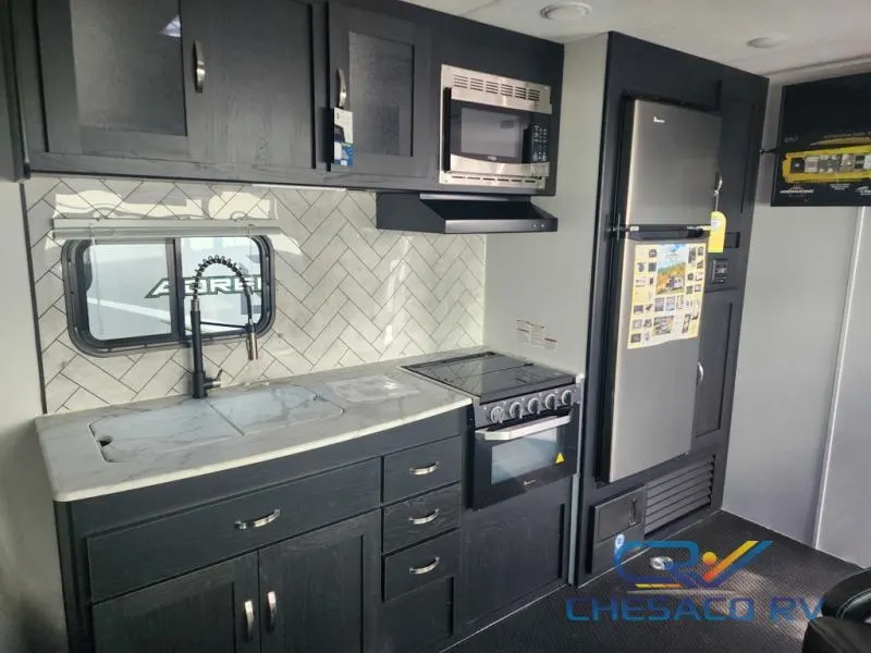 Kitchen with a gas range, fridge, oven, sink and cabinets.