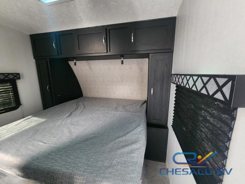 Bedroom with a king size bed, overhead cabinets and shirt closets.