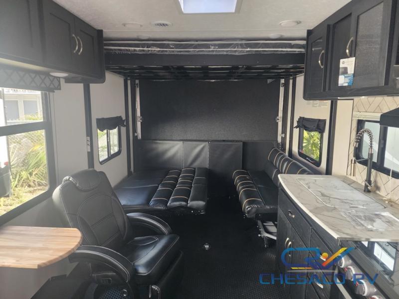 Interior view of the RV with a dinette, living space and a kitchen.