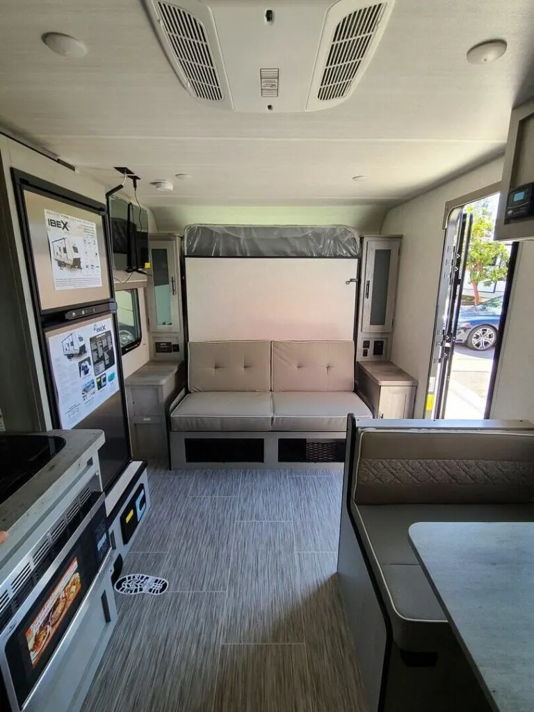 Interior view of the RV with a dinette, living space and a kitchen.