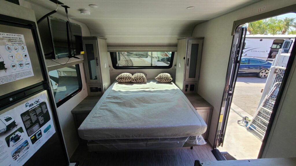 Bedroom with a queen size bed, TV and shirt closets.