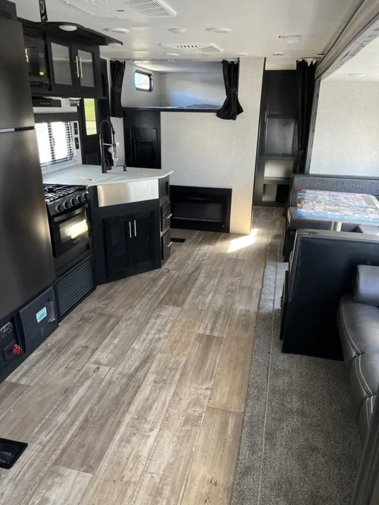 Interior view of the RV with a dinette, living space and a kitchen.