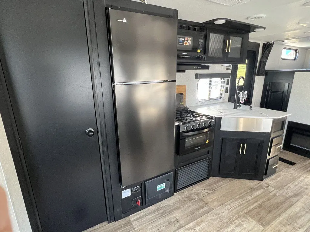 Kitchen with a gas range, fridge, oven, sink and cabinets.