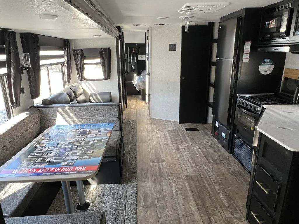 Interior view of the RV with a dinette, living space and a kitchen.