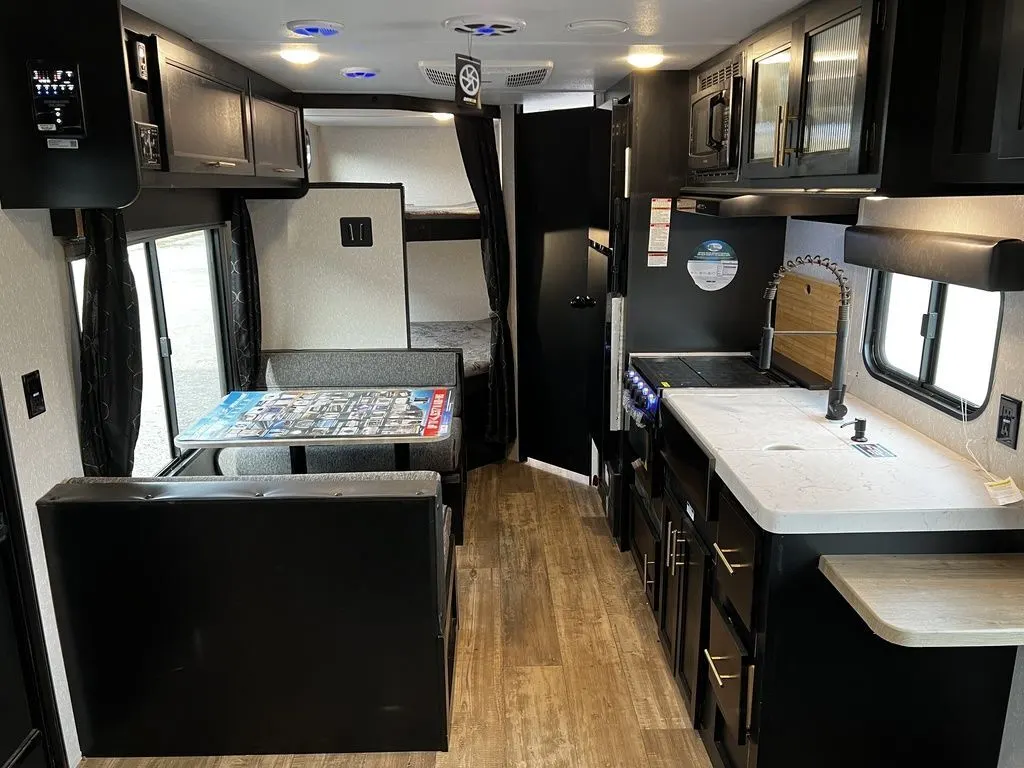 Interior view of the RV with a dinette, bedroom and a kitchen.