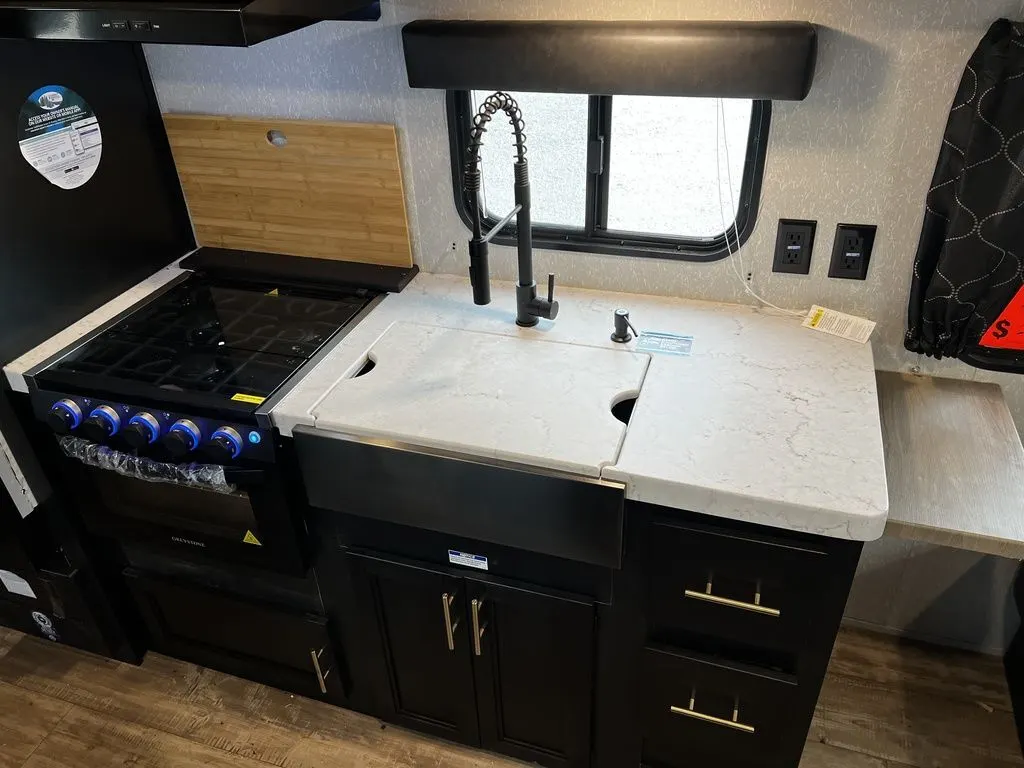 Kitchen with a gas range, sink and cabinets.