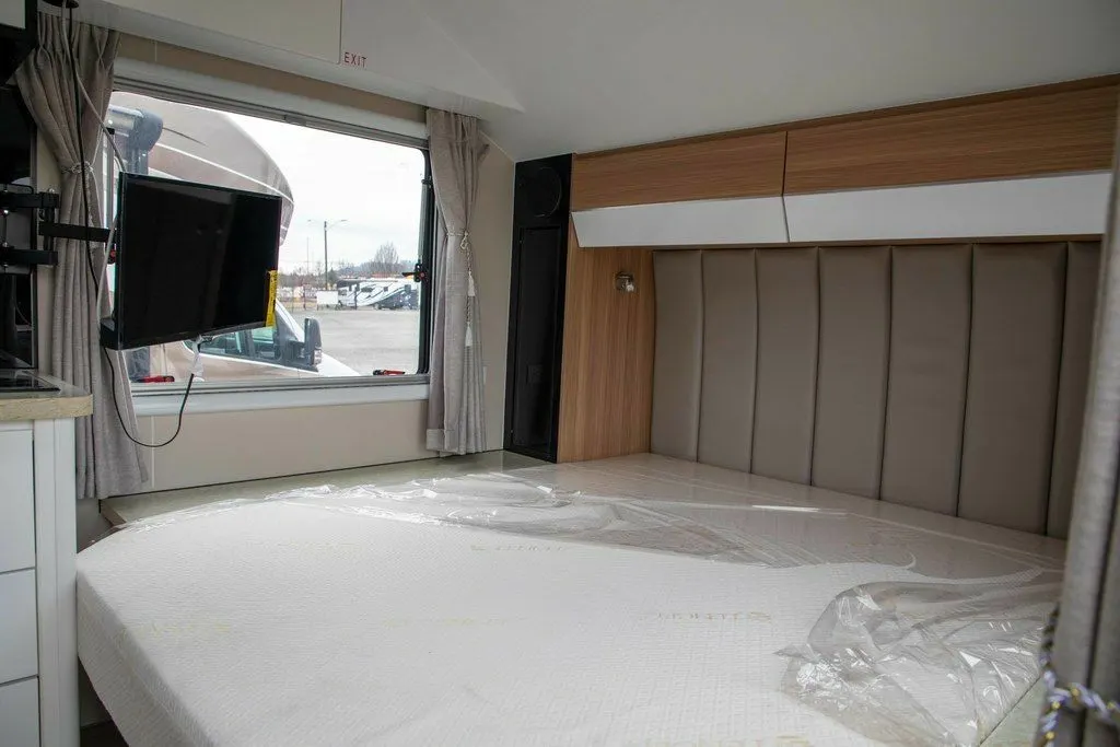 Bedroom with a queen size bed and a TV.