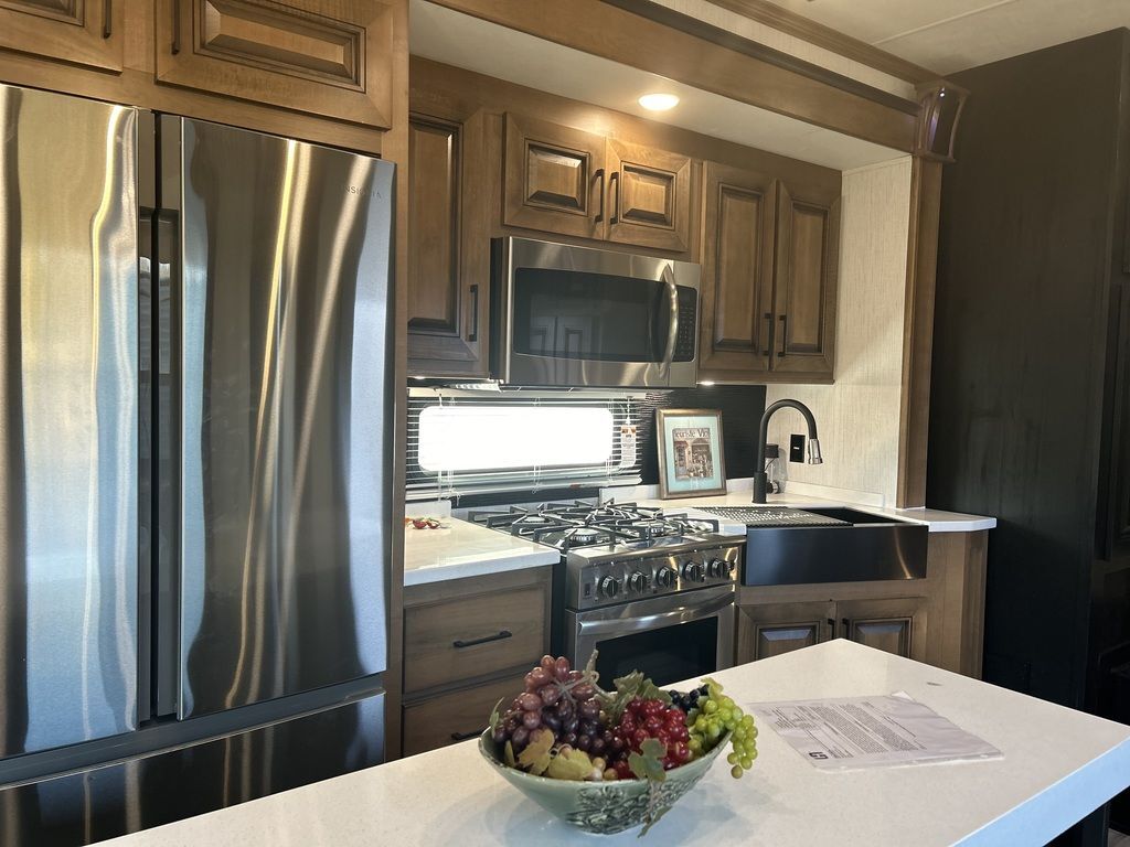 Kitchen with a gas range, fridge, oven, sink and cabinets.