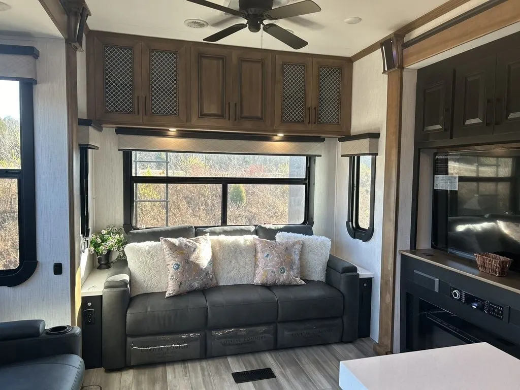 Living space with leather seats and overhead cabinets.