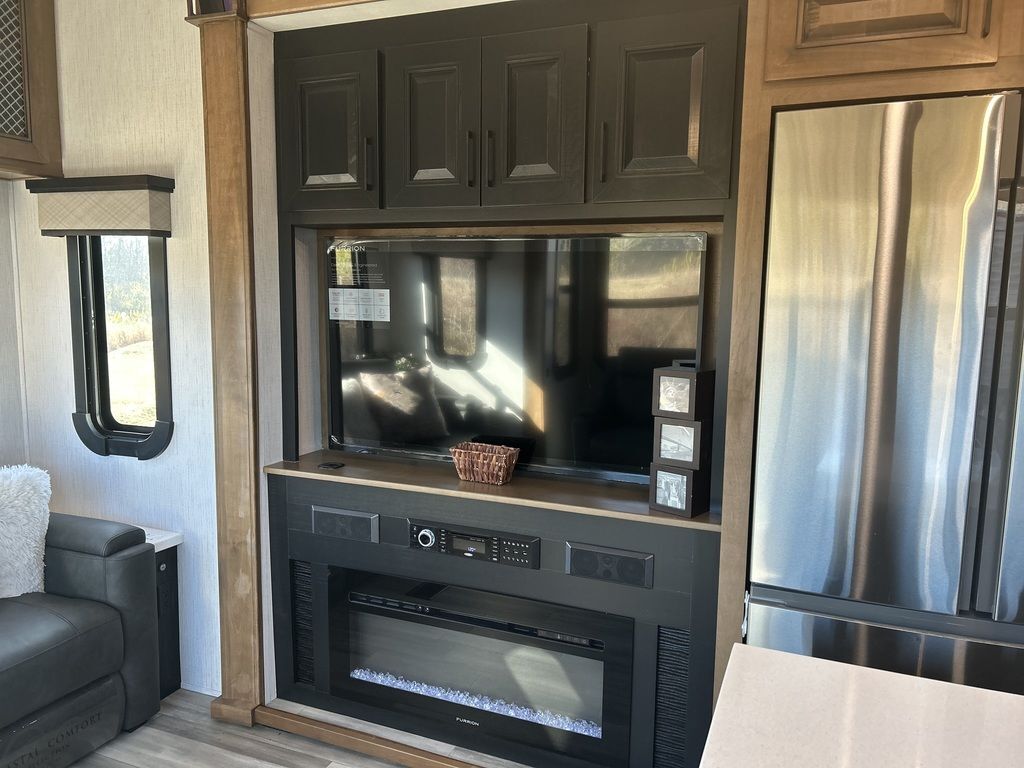 Entertainment center with a TV and a fireplace.