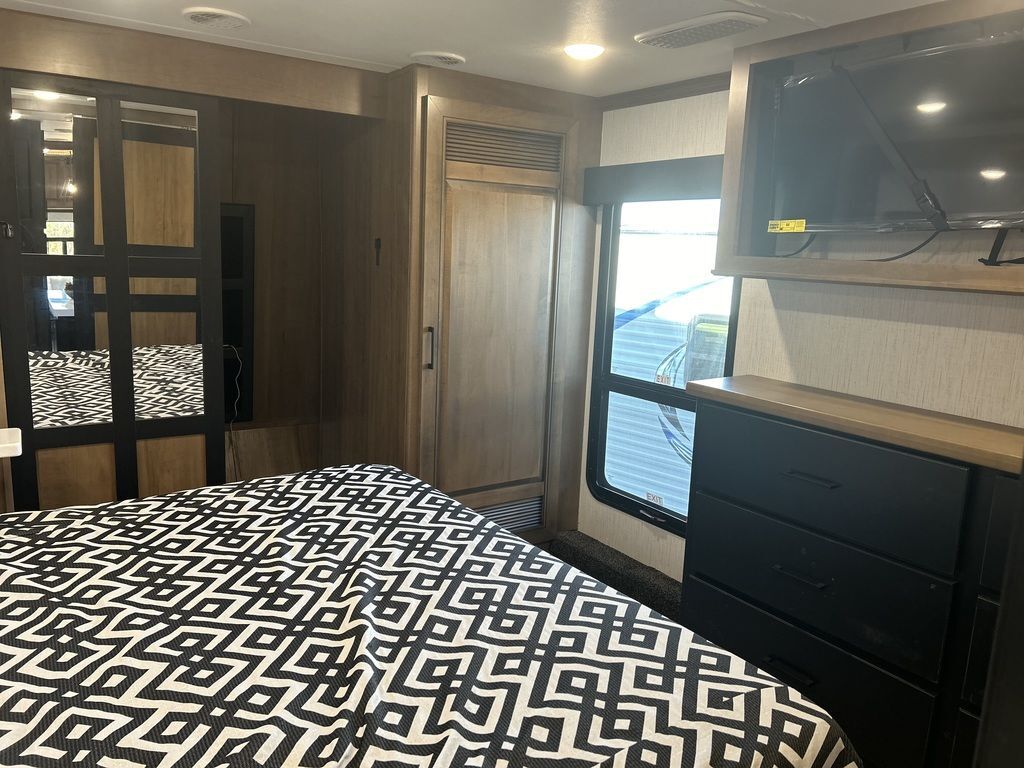 Bedroom with a king size bed, TV, drawer and a closet.