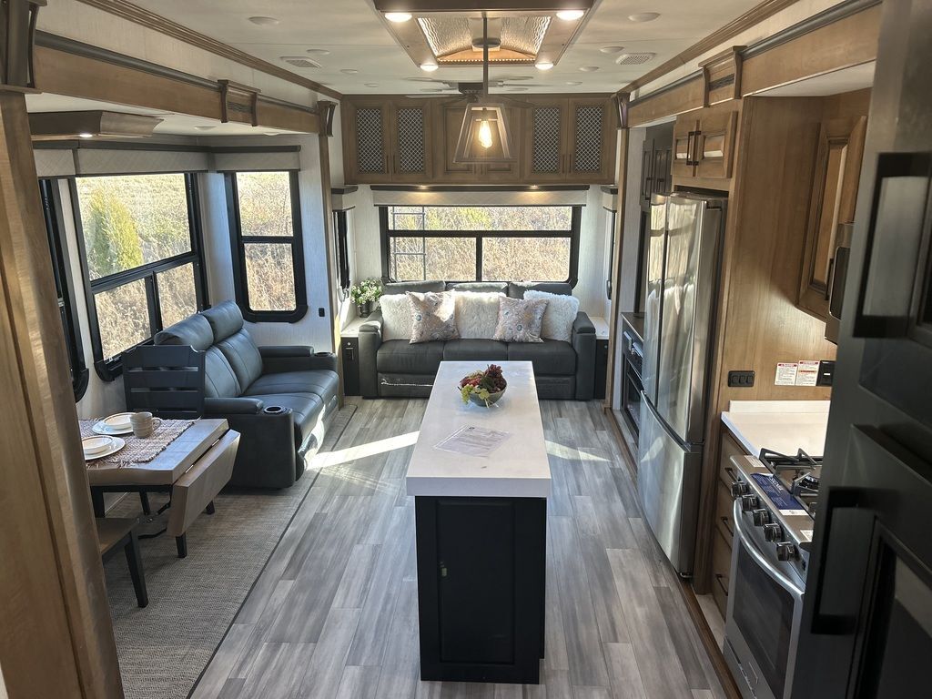 Interior view of the RV with a dinette, living space and a kitchen.