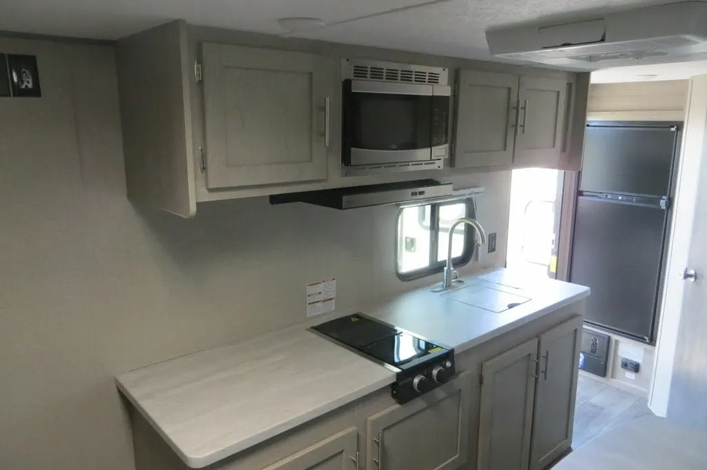 Kitchen with a gas burner, fridge, oven, sink and cabinets.