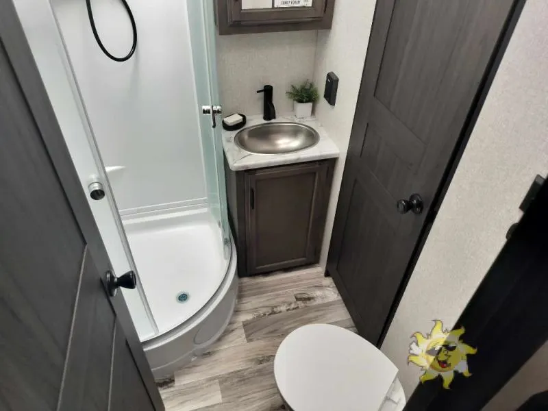 Bathroom with a sink, toilet and a walk-in shower.