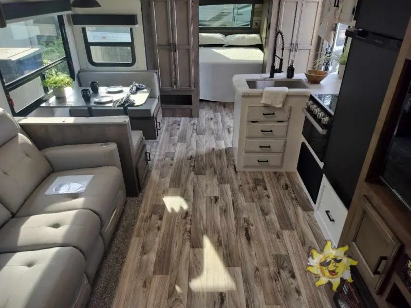 Interior view of the RV with a dinette, living space and a kitchen.