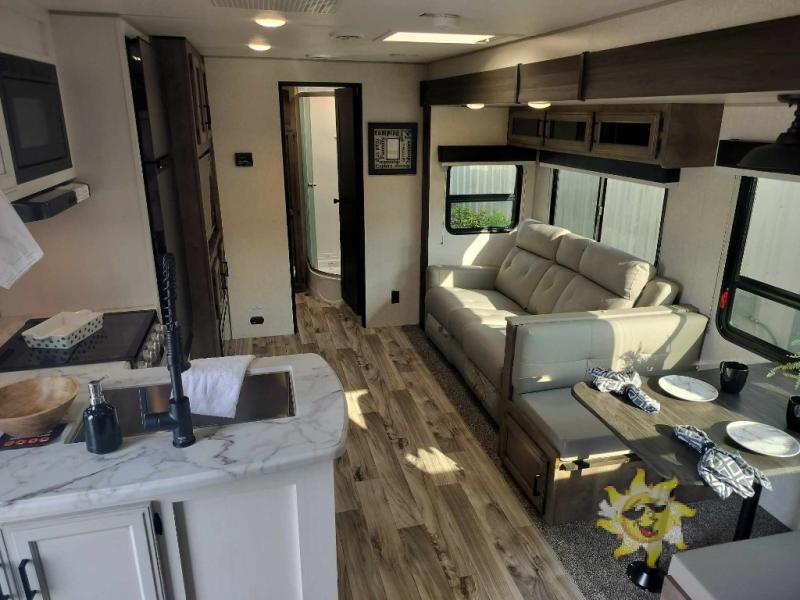 Interior view of the RV with a dinette, living space and a kitchen.