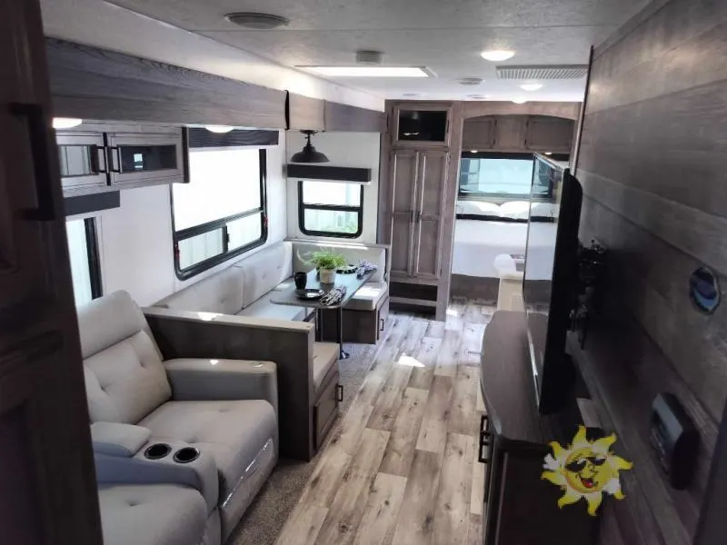 Interior view of the RV with a dinette and a living space.