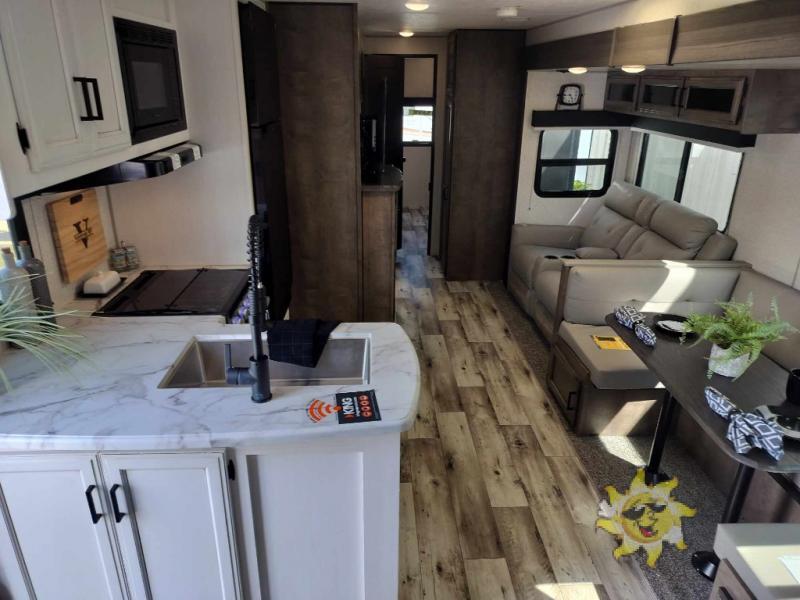 Interior view of the RV with a dinette, living space and a kitchen.