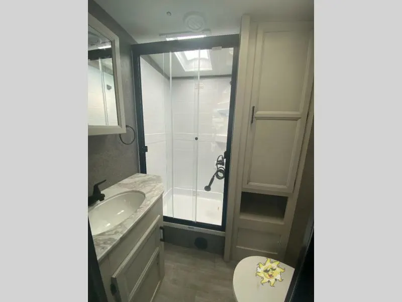 Bathroom with a sink, toilet and a walk-in shower.