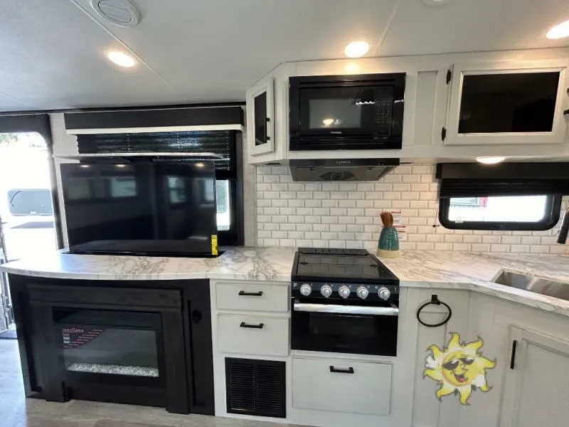 Entertainment center flanked by the kitchen.