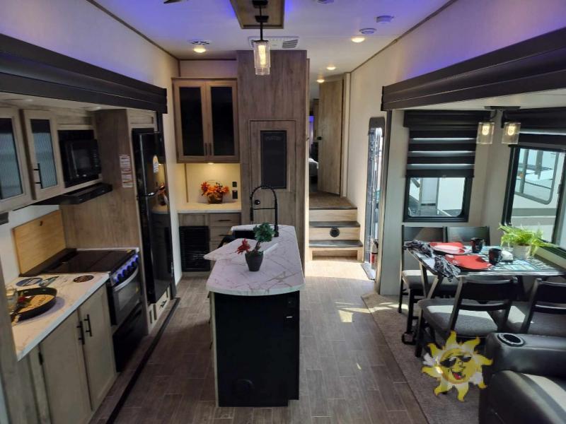 Interior view of the RV with a dinette, living space and a kitchen.