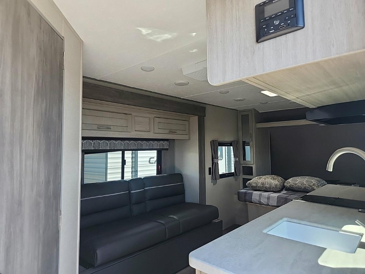 Living space with leather seats and overhead cabinets.  