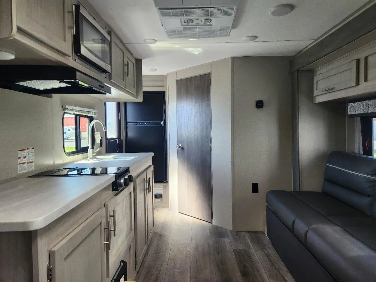 Kitchen with a gas burner, oven, sink and cabinets.