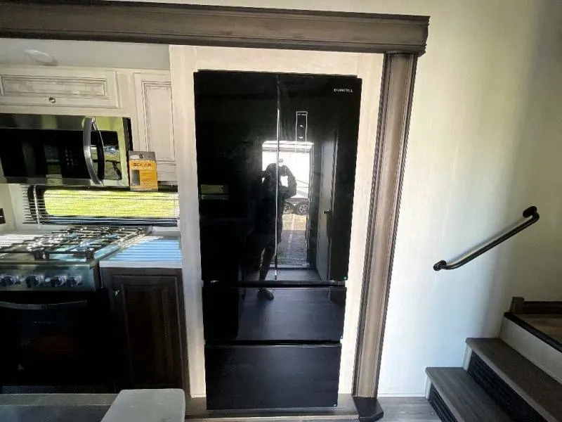 Kitchen with a gas burner, fridge, oven, and cabinets.