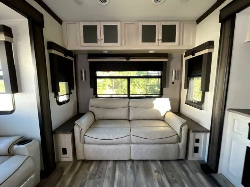 Living space with leather seats and overhead cabinets. 