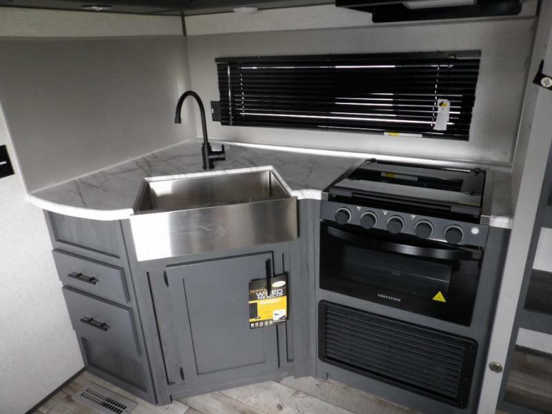 Kitchen with a gas burner, sink and cabinets.