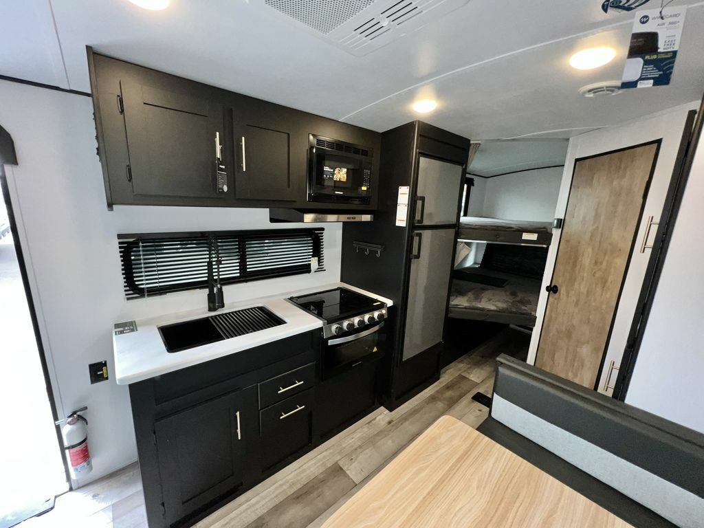 Kitchen with a gas burner, fridge, oven, sink and cabinets.