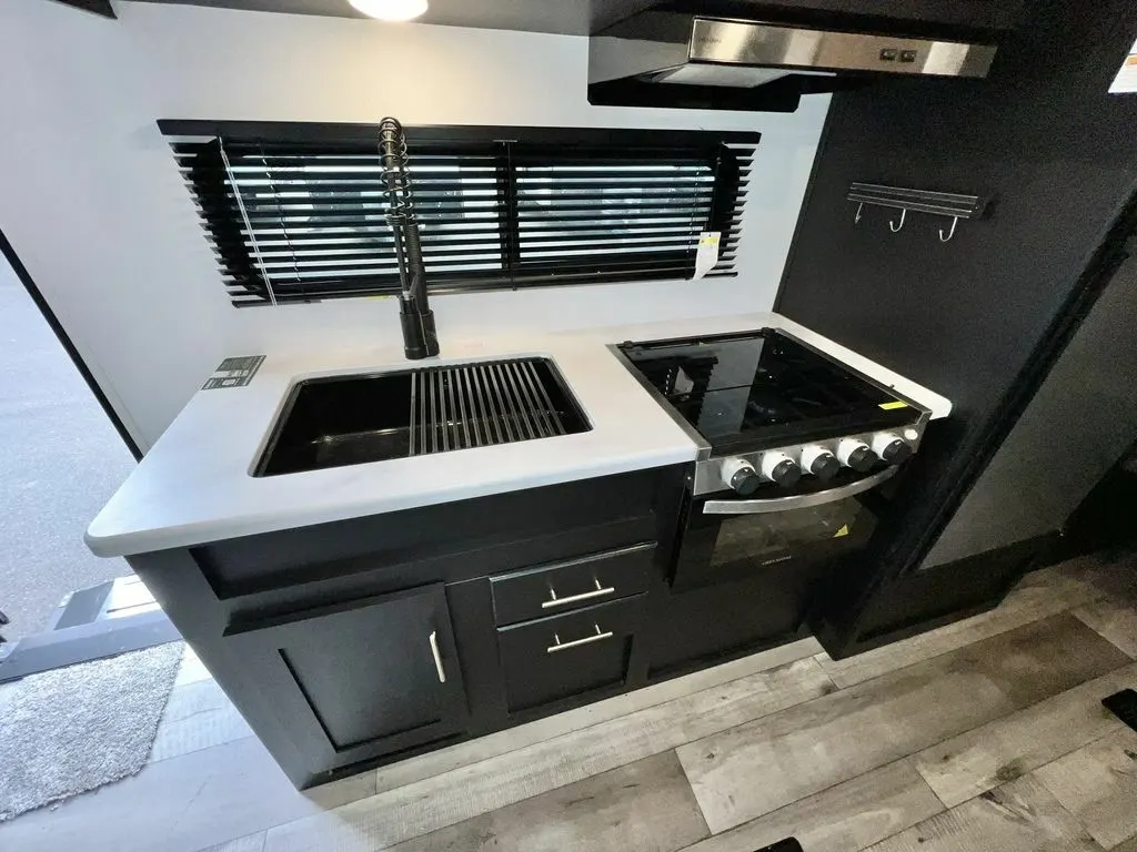 Kitchen with a gas burner, fridge, sink and cabinets.