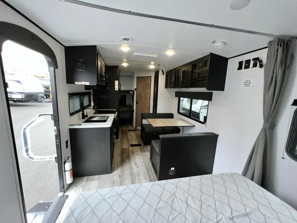 Interior view of the RV with a dinette, bedroom and a kitchen.