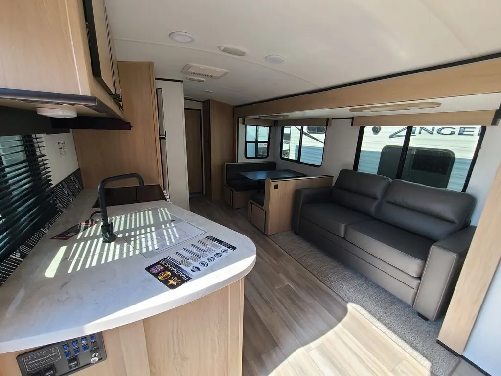 Interior view of the RV with a dinette, living space and a kitchen.