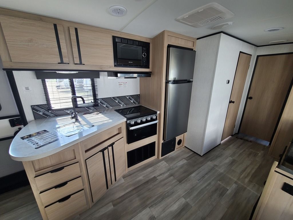 Kitchen with a gas range, fridge, oven, sink and cabinets.