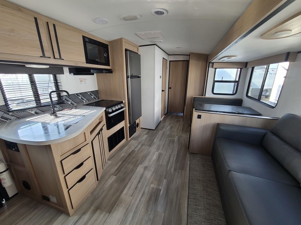 Interior view of the RV with a dinette, living space and a kitchen.