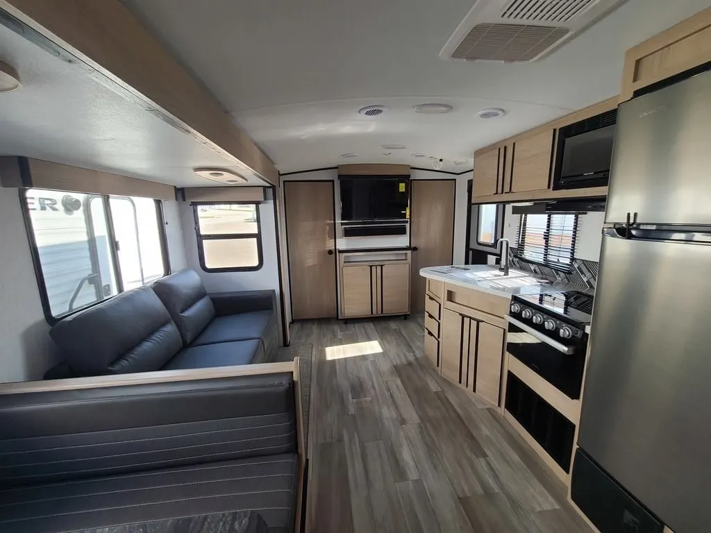 Interior view of the RV with a dinette, living space and a kitchen.