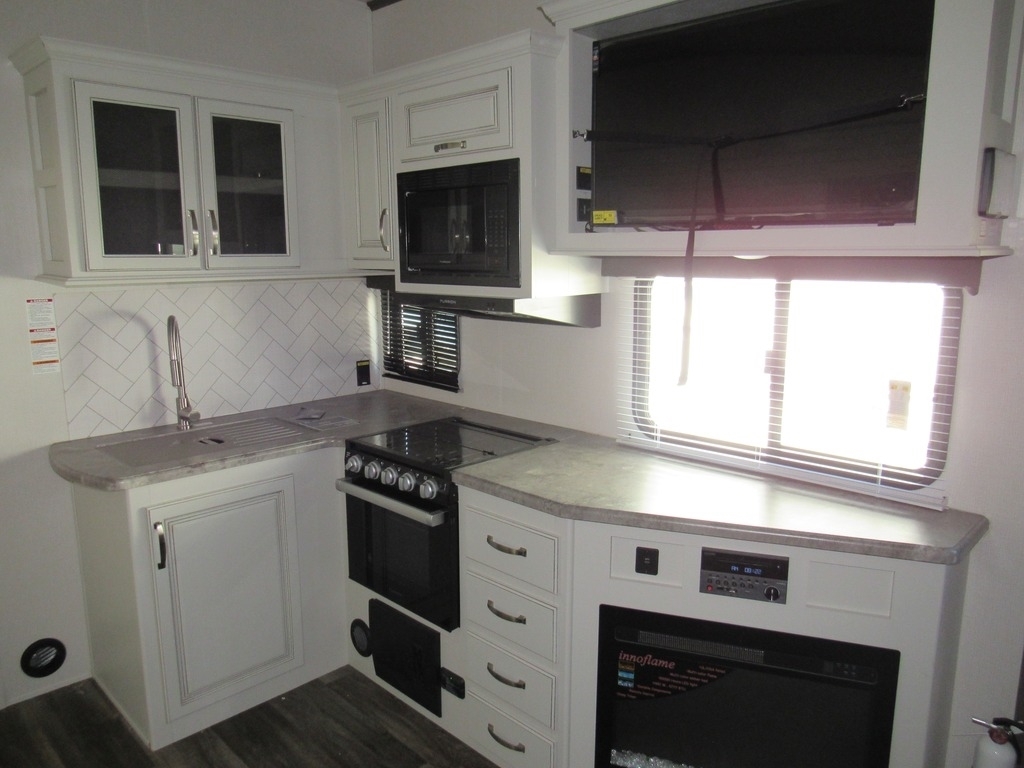 Kitchen with a gas burner, oven, sink and cabinets.