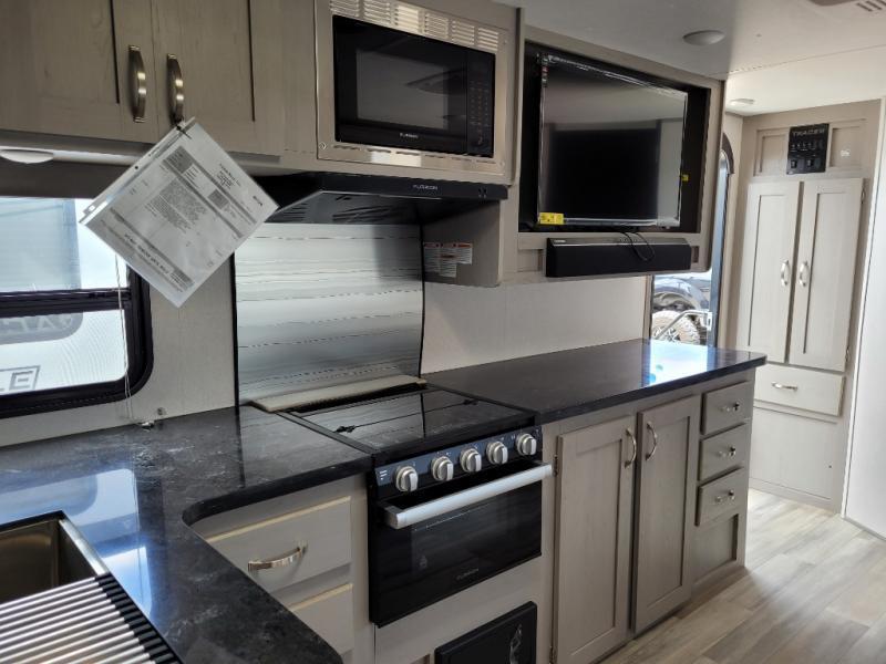 Kitchen with a gas range, oven, TV and cabinets.