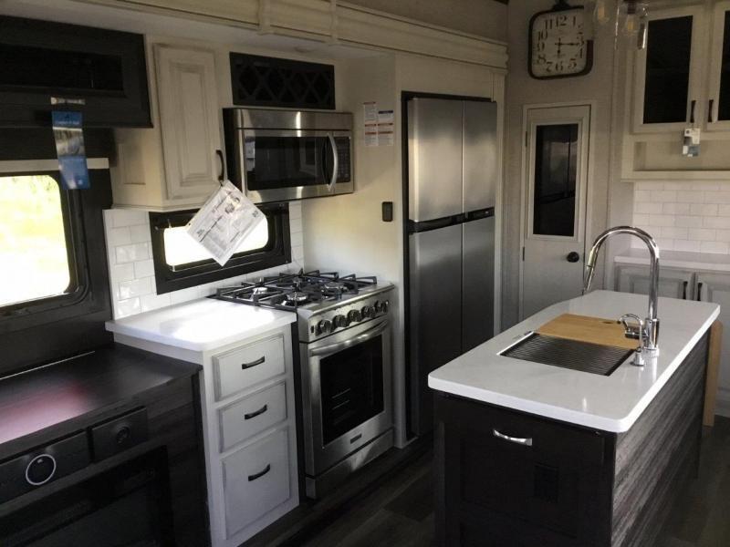 Kitchen with a gas range, fridge, oven, sink and cabinets.