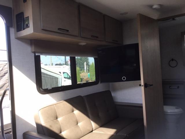 Living space with leather seats and overhead cabinets.  