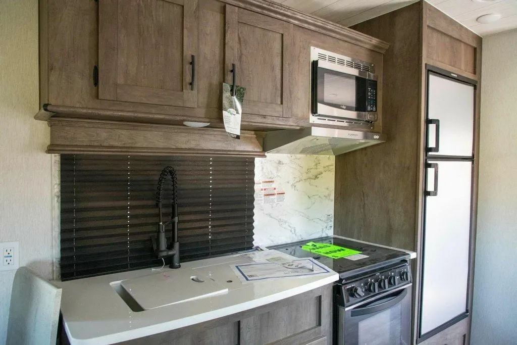 Kitchen with a gas burner, fridge, oven, sink and cabinets.